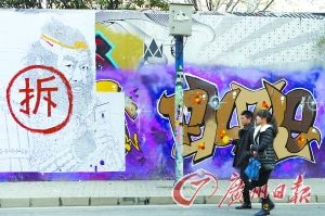 上海莫干山路，行人从涂鸦墙上写着的“拆”字前经过。