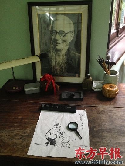 旧居二楼“日月楼”中的一张画桌上放着丰子恺的照片和他的画作。俞凯 图