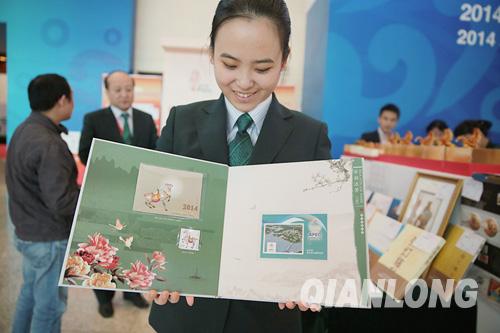 11月6日，中国邮政工作人员在国家会议中心APEC新闻中心向记者展示APEC邮票纪念张。千龙网记者 李贺摄