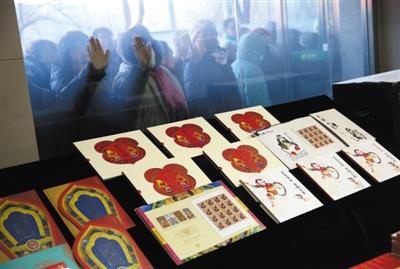 昨日，水碓子邮局，在外面排队的市民隔着玻璃对“丙申年”生肖猴票先睹为快。新京报记者 薛珺 摄