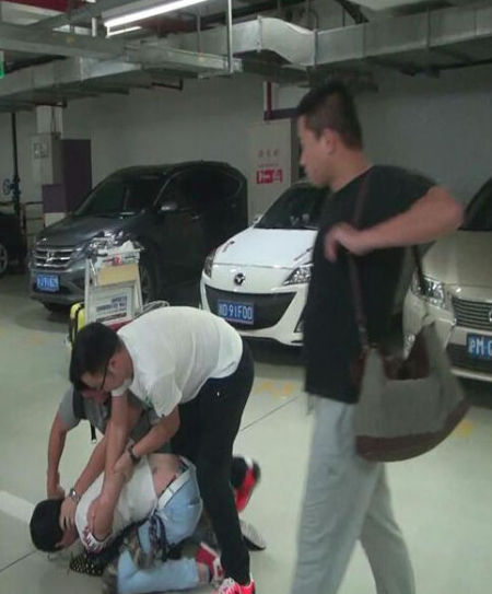 图为办案人员在机场停车场抓获胡某及其女友。