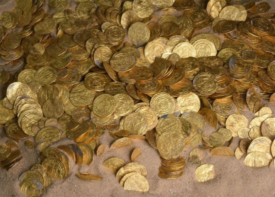 图为考古人员在水下发现的金币。