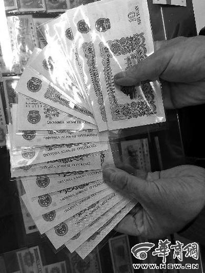 在西安西华门附近的邮币市场内，一位店老板拿了一叠钱币向华商报记者展示 