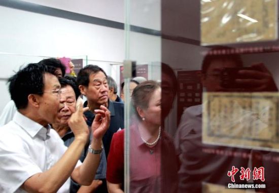 图为民间收藏家张国柱向参观者介绍革命政权的货币发行。马智峰 摄