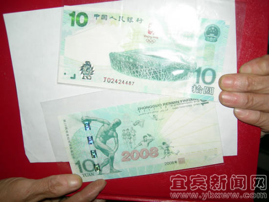 世明展示全新品相的2008版奥运纪念钞。（宜宾新闻网 王喻 摄）