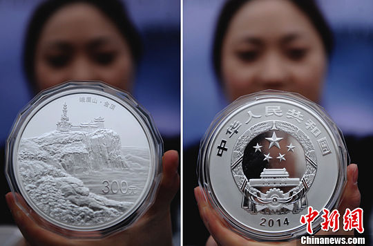 3月21日，工作人员展示面值300元1公斤重的圆形银质纪念币（拼图）。中新社发 刘忠俊 摄