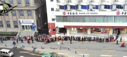 12月24日，成都市民在红星路二段中国银行门口，排队兑换“马年纪念币”。