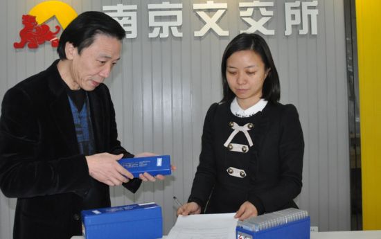 陈家全先生(左)清点南京文交所钱币邮票交易中心交割的PCGS乒乓球评级币