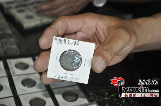 刘先生在展示印度古钱币。亚心网记者 马永平 摄 