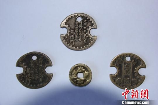 图为王兆生收藏的四枚铜钱，其中其中一个很厚的圆铜钱，上面刻的“崇宁通宝”四个字还依稀可辨。 谭地 摄