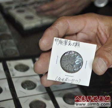 图为刘先生在展示印度古钱币