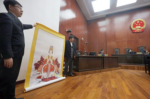 庭审中，上诉人举着长3米，宽2米的妈祖画像的复制品作为证据，向法庭出示 摄/法制晚报记者杨益