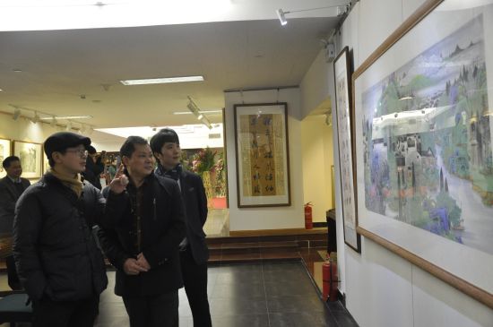 东方啸先生(左二)与国家画院信息中心主任王平先生(左一)、中国艺术投资网总裁鲜大杰先生(右一)观看展览作品