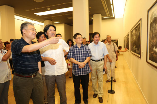 中国文联党组成员、书记处书记郭运德（左一）出席展览开幕式并观看展览 张志勇摄