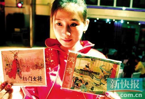 连环画拍卖现场,工作人员在展示《杨门女将》和《虎符》。CFP供图(资料图片)