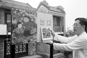 胡锦雄拿出自己画册与岭南印象园的指示牌做对比。信息时报记者 卢一鸣 摄