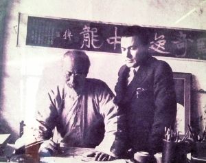 捷克汉学家观齐白石作画的老照片，背景为书法拓片