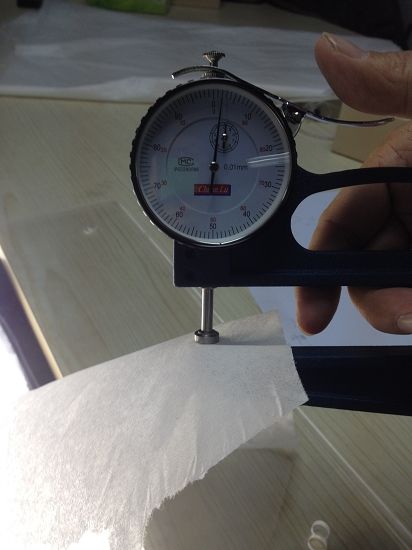 用仪器检测纸张厚度。