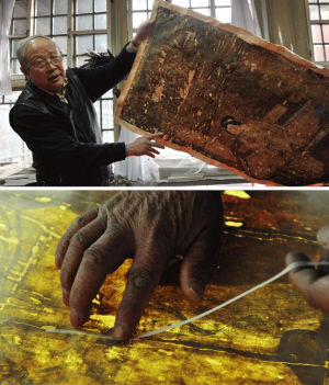 古书画修复专家徐建华展示一幅破旧、等待修复的古画。