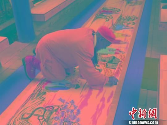 释持忠在为作品《五百罗汉朝菩萨图》盖章。 于金贵 摄