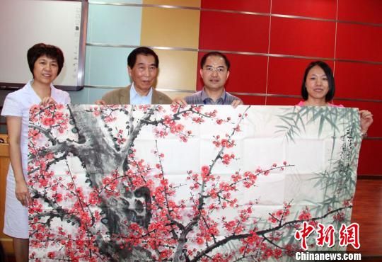 南岭梅向母校梅州中学捐赠自己的画作。 蔡欣欣 摄