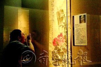 喜爱齐白石大师的卜先生“恨不得”贴在画上。　本报记者　陈莹　摄