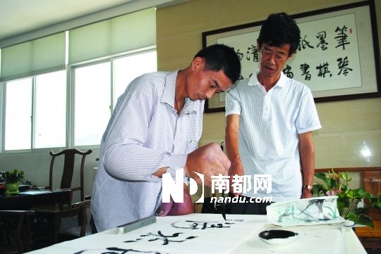 王沅宁在老师的指导下练字。南都记者 曾海城 摄