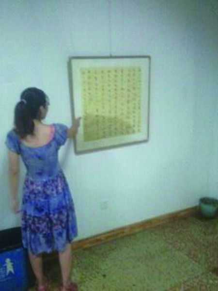 一些商户挂在墙壁上的字画底部仍有水痕 记者陈晶摄