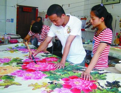 在广西桂林市临桂县五通镇，“80后”的年轻人已成为创作农民画的中坚力量。图为五通农民画画家蒋国康在教学员作画。周荣华 摄