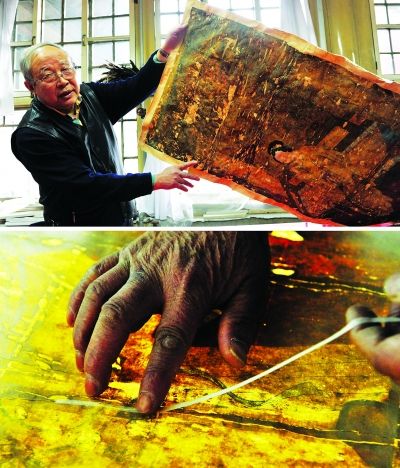 年过六旬的古书画修复专家徐建华展示一幅破旧的古画。新华社发