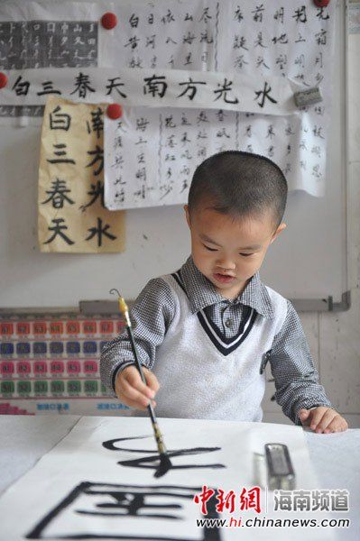 今年刚满4岁的男童吴冠桦在写毛笔书法。