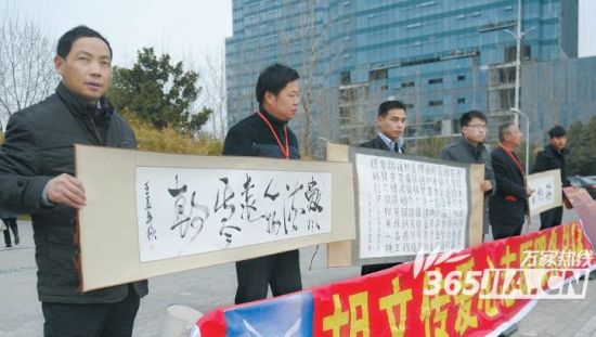 昨日，杏花公园门前，大义父亲胡文传(左)等热心人也来帮朱传健卖画。