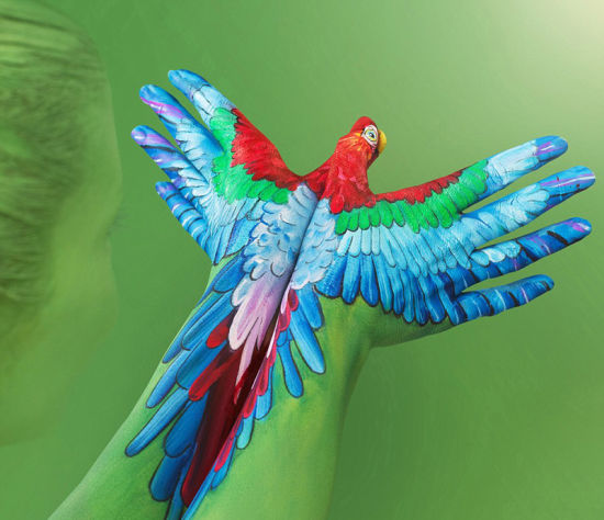凯特在模特手上彩绘创造出这幅鹦鹉起飞图。（网页截图）