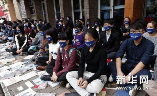 11月23日，参与者戴着“今天不说话”的口罩静坐在街头。新华网图片 凡军 摄