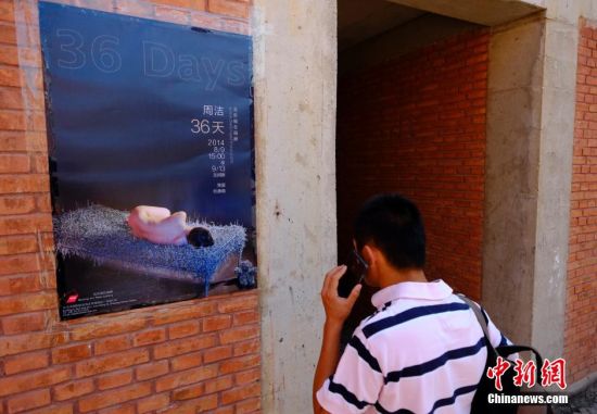 8月12日，位于北京草场地艺术中心举办“裸女睡钢丝床”行为艺术展的某画廊外，一名男性正在打电话联系策展方，询问展览为何“闭门谢客”。8月9日，一位女行为艺术家在此举办题为《36天》的展览，她计划裸睡在钢丝床上36天，期间将正常吃饭、睡觉等，引起关注。 中新社发 侯宇 摄