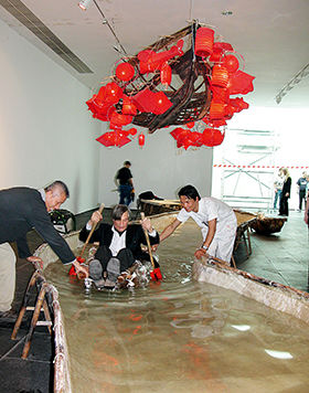 蔡国强协助杨·荷特乘坐牛皮筏，摄于比利时根特S.M.A.K。当代美术馆，2003年 (摄影/Dirk Pauwels S.M.A.K。当代美术馆供图)
