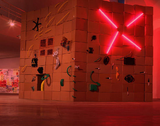 参展艺术家之一原弓作品：记忆·感谢妓女，旧纸板箱、黄与绿色胶带、红色灯管、旧生活用品等杂物，尺寸可变，2014