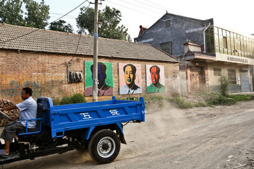 三张两米高的波普毛泽东画像悬挂在仇庄的主路旁，最初村民们不太能接受，现在也已经习以为常了。摄影/李牧