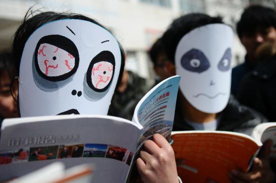 3月21日，在山东聊城大学校园内，几名大学生志愿者用行为艺术演绎熬夜看书行为。