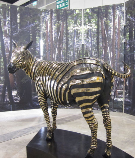 香港艺博会主画廊展厅里的斑马雕塑，金碧辉煌。