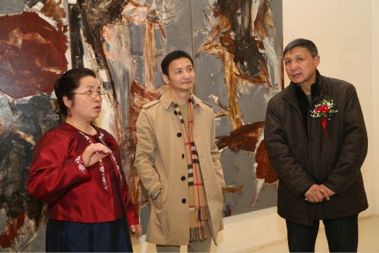 画家金善与著名批评家杨卫、上苑艺术联合会会长李向明在展览现场交流作品