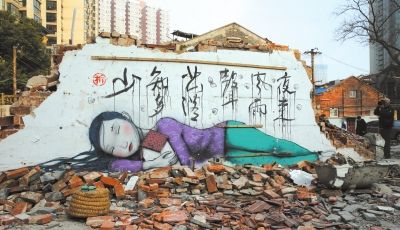 1月23日，一名摄影爱好者在一幅涂鸦作品旁取景创作。新华社发