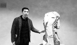 吴彤向记者讲述自己将中国京剧脸谱与雕塑相融合的创作思路。毕馨月 摄