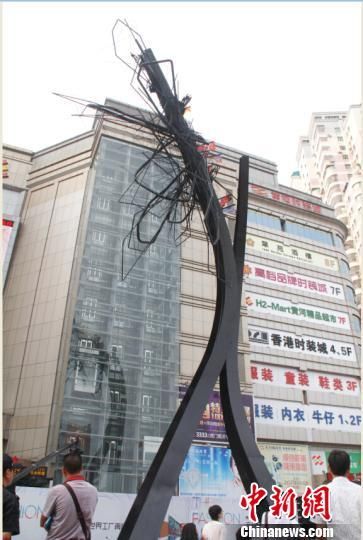 世界级艺术大师阿纳 奎兹历时一年打造的30米高公共艺术作品——“自然混沌”28日在广东东莞虎门建成。图为公共艺术作品——“自然混沌”引来民众驻足观看。 王俊伟 摄