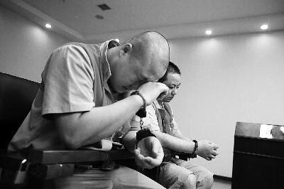 　在法庭上，被告人梅某(左一)始终低着头，不时用手抹泪 摄/法制晚报记者 王晓飞