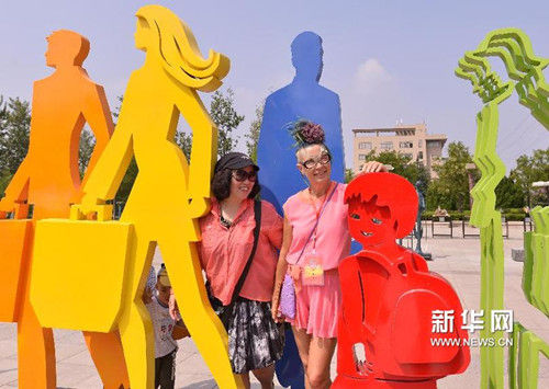 8月19日，参观者欣赏中国雕塑家沈允庆创作的雕塑《来来往往》。（宁友鹏 摄）