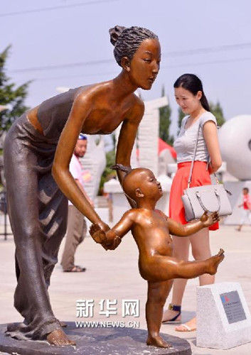 一名参观者在中国雕塑家章华创作的雕塑《第一步》旁驻足。（宁友鹏 摄）