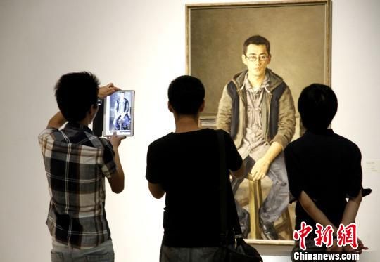 8月12日，民革中央画院主办的“民革中央画院首届油画展”在北京中国油画院美术馆开幕，民众欣赏画作。　陈小愿　摄