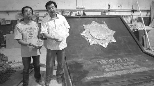 7月8日,邹锋(右)和赵覃(左)站在之前准备的独立自由勋章雕塑版本前。　本报记者郑雷摄