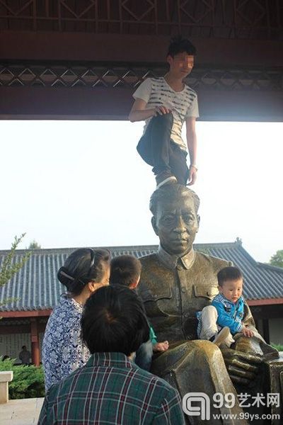 男子脚踩刘少奇塑像头部拍照